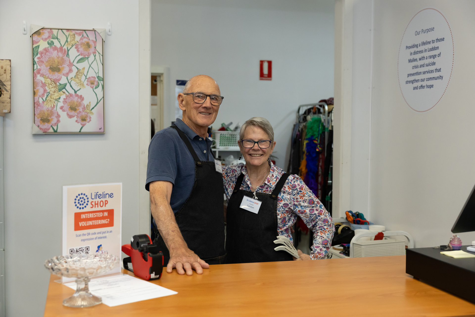 Two shop volunteers behind counter