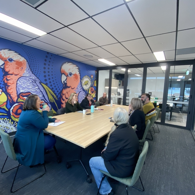 Group meeting in Board room with large mural