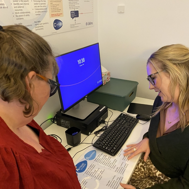 Two women looking at share document in front of computre