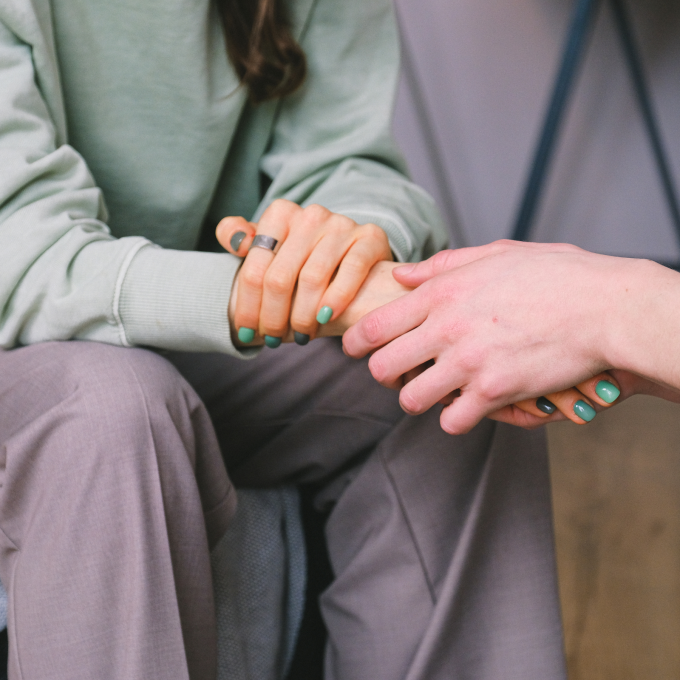 Person sitting holding hands